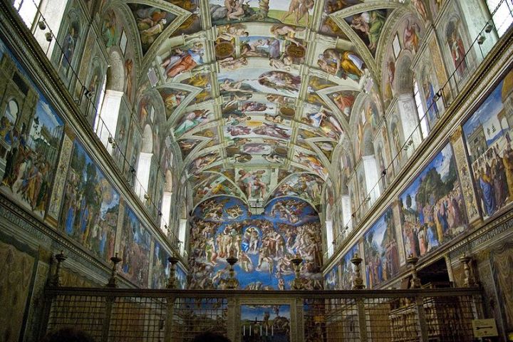 Ornate frescoes and paintings cover the ceiling and walls of an elaborate chapel interior.