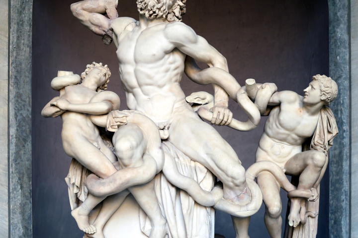 Ancient statue of three figures entangled by serpents, showing dramatic expressions and contorted poses.